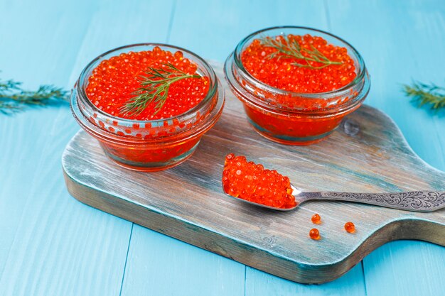 Caviar rouge dans un bol en verre et dans une cuillère, vue de dessus