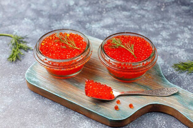 Caviar rouge dans un bol en verre et dans une cuillère