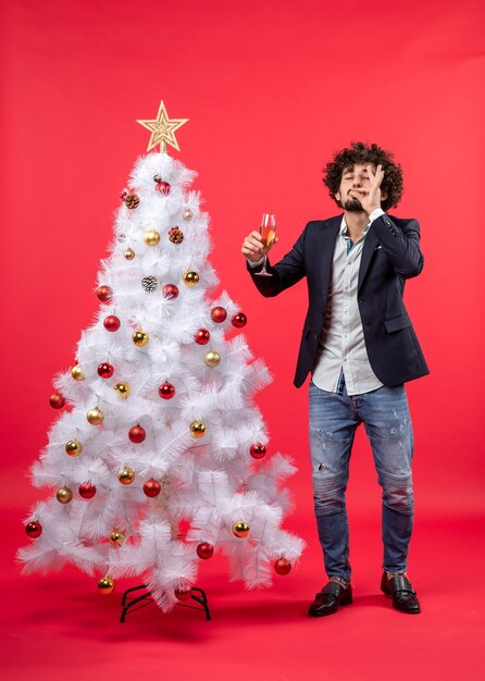 Célébration du nouvel an avec un jeune homme choqué tenant un verre de vin faisant un geste parfait