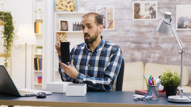 Célèbre influenceur enregistrant le déballage d'un téléphone moderne. Créateur de contenu créatif.