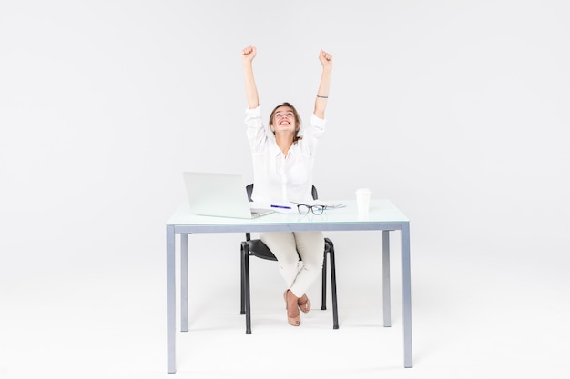 Célébrer la femme d'affaires au bureau avec ordinateur portable isolé sur fond blanc