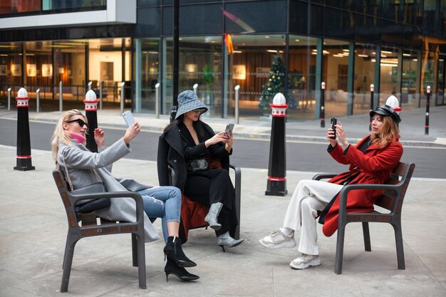 Célébrités Internet prenant un selfie assis sur des bancs