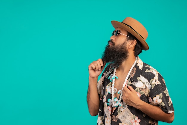 Celui d'un homme heureux avec une longue barbe coiffé d'un chapeau, vêtu d'une chemise rayée montrant un geste sur un bleu.