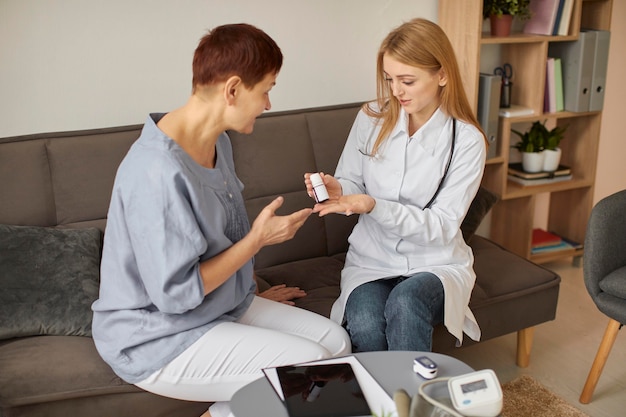 Centre de récupération Covid, femme médecin donnant des pilules à un patient âgé