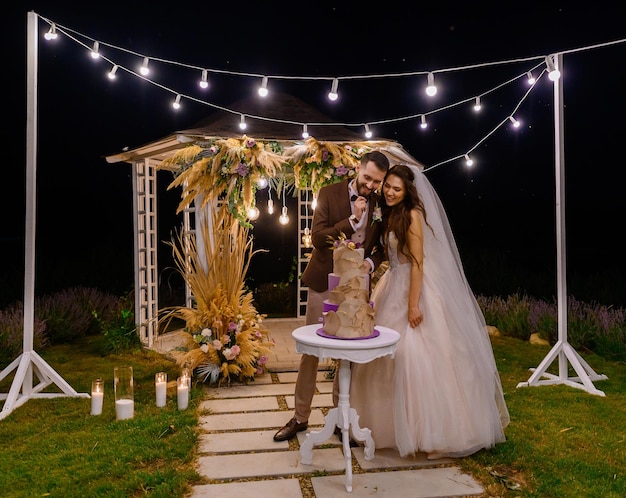 Cérémonie du soir en plein air de la mariée avec gâteau de mariage traditionnel