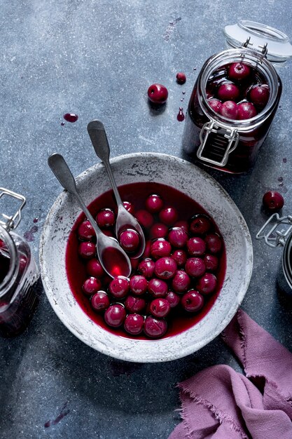 Cerise au marasquin dans un bol et bocal en verre à plat la photographie alimentaire