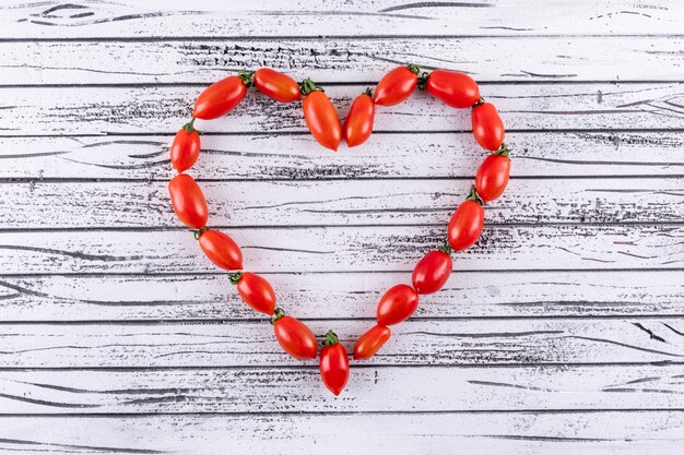 Cerise rouge fraîche en forme de coeur sur une surface en bois blanc