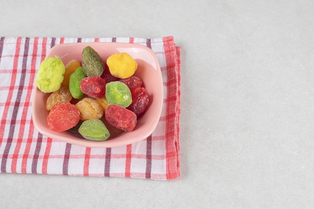 Photo gratuite cerise sèche et abricots colorés dans une tasse en céramique.