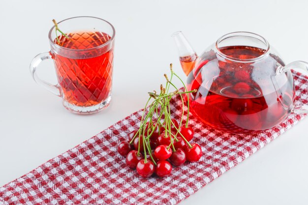 Cerise avec vue grand angle de thé sur blanc et torchon de cuisine