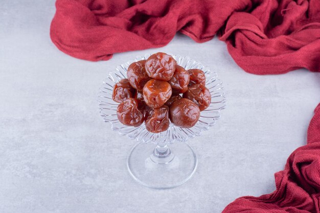 Cerises aigres brunes à moitié séchées dans une tasse sur fond de béton. photo de haute qualité