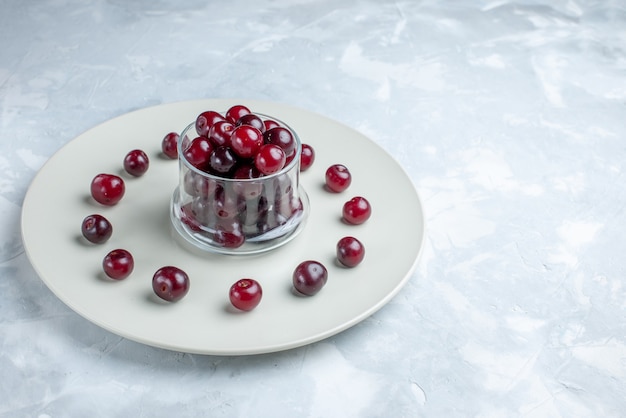 Photo gratuite cerises aigres fraîches à l'intérieur de la plaque sur blanc clair