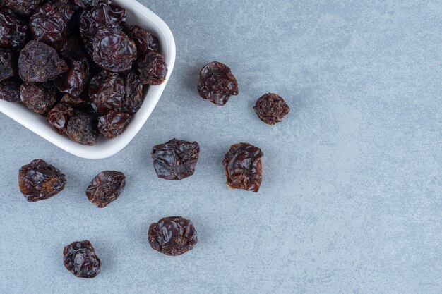 Cerises aigres séchées dans le bol, sur la table en marbre.