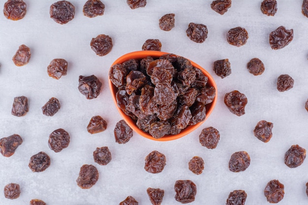 Photo gratuite cerises aigres séchées dans une tasse sur fond de béton. photo de haute qualité