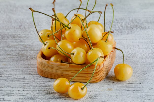 Cerises dans une assiette en bois sur un grungy. vue grand angle.