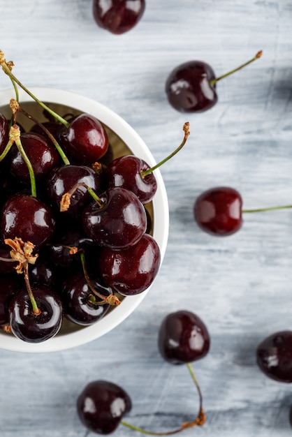 Cerises dans un bol sur la surface grunge, gros plan.