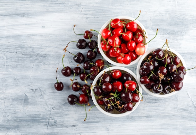 Cerises dans des bols vue de dessus sur une surface grunge