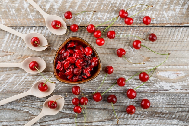 Cerises dans des cuillères en bois avec de la confiture sur bois