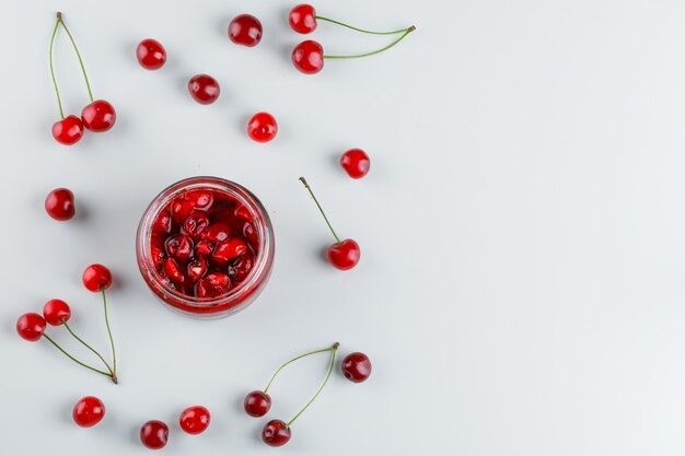 Cerises dans un verre à vin sur blanc