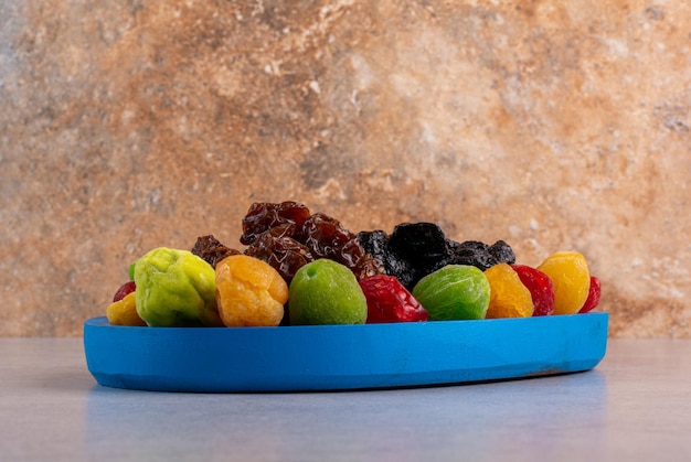 Photo gratuite cerises et fruits séchés colorés sur une surface en béton.