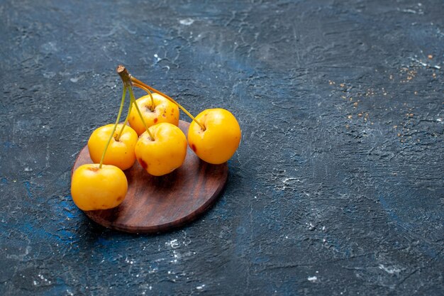 Cerises jaunes fraîches fruits mûrs et sucrés isolés sur des baies de fruits sombres, fraîches moelleuses