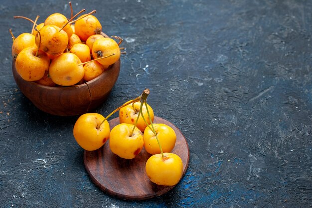 Cerises jaunes fraîches fruits mûrs et sucrés isolés sur des baies de fruits sombres, frais