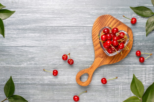 Cerises rouges dans un bol sur une table grise