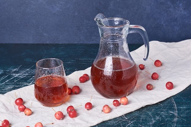 Photo gratuite cerises avec une tasse de boisson sur bleu.