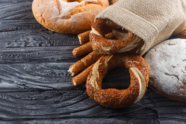 Certains produits de boulangerie avec du pain, bagel turc sur une surface en bois gris, high angle view.