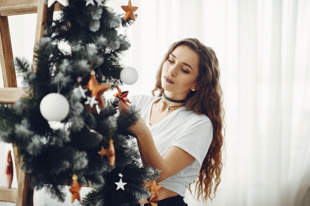 Cgirl mignon à la maison près d'un arbre de Noël