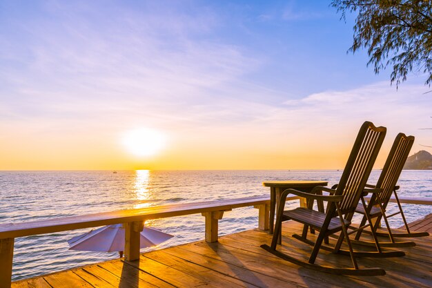 Chaise en bois vide et table au patio extérieur avec belle plage tropicale et la mer