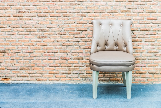 Photo gratuite chaise en cuir de luxe sur fond de mur de brique