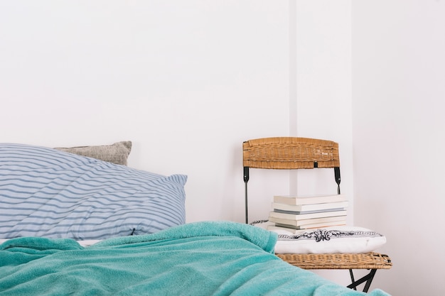 Chaise avec oreiller et livres près du lit