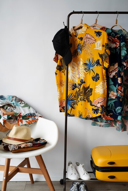 Chaise et portant à vêtements avec chemises hawaïennes à imprimé floral et chapeau