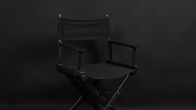 Chaise de réalisateur noir isolée sur fond noir.