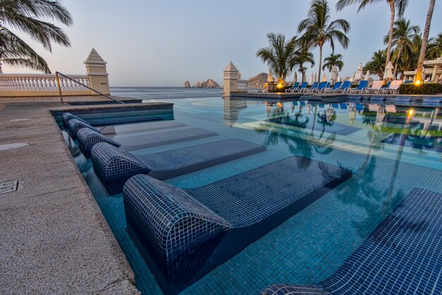 Chaises longues bleues sur la piscine