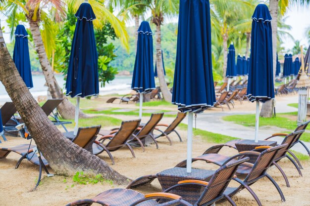 Des chaises longues et des parasols bleus