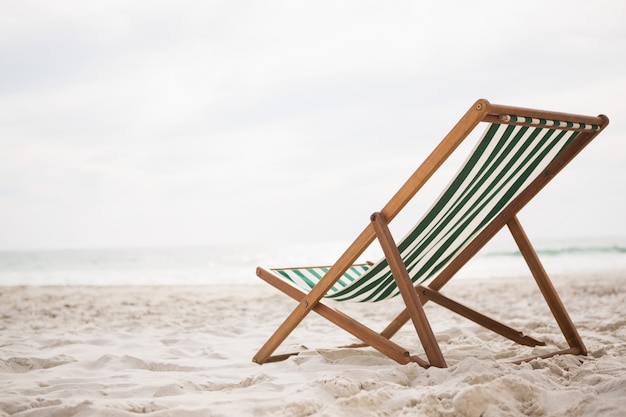 Les chaises de plage sur la plage tropicale de sable