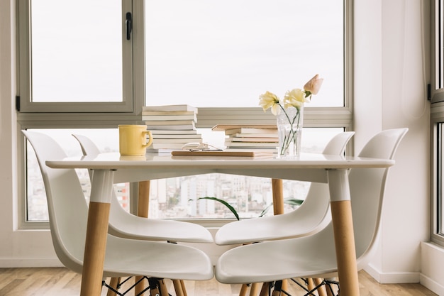 Photo gratuite chaises près de table avec des livres et des décorations