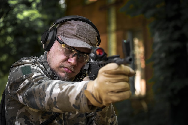 Champ de tir extérieur Cours d'action d'arme de fusil de chasse Tireur avec une arme à feu en uniforme militaire