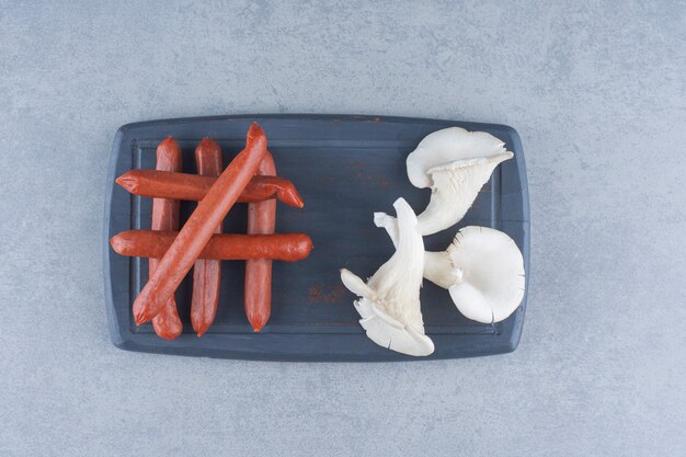 Photo gratuite champignon huître et salami sur tableau noir.