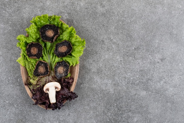 Photo gratuite champignons cuits avec assiette en bois de fils verts.