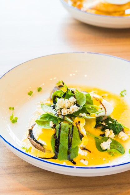 Champignons et oeufs bénédicte en assiette blanche