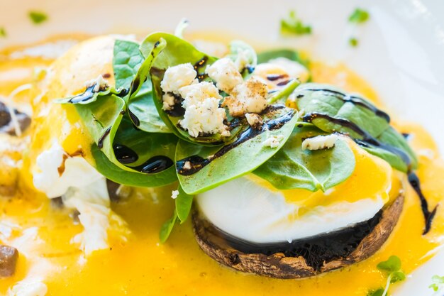 Champignons et oeufs bénédicte en assiette blanche