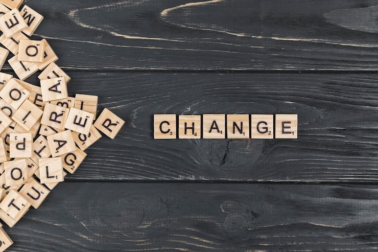 Photo gratuit changer le mot sur fond en bois