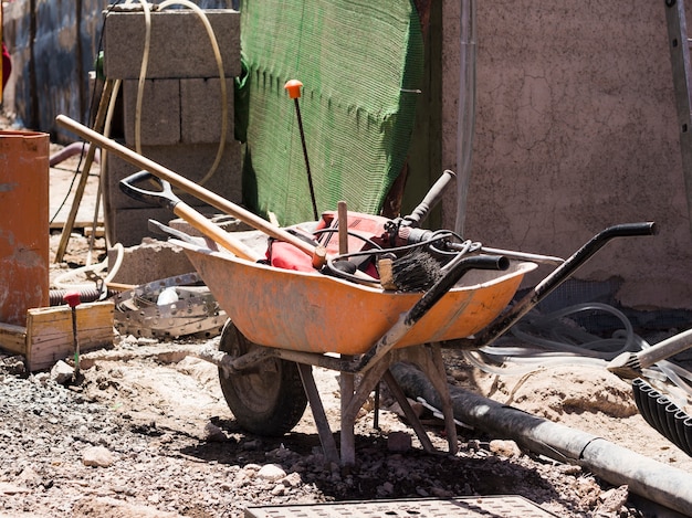 Chantier de construction avec une brouette remplie d'outils