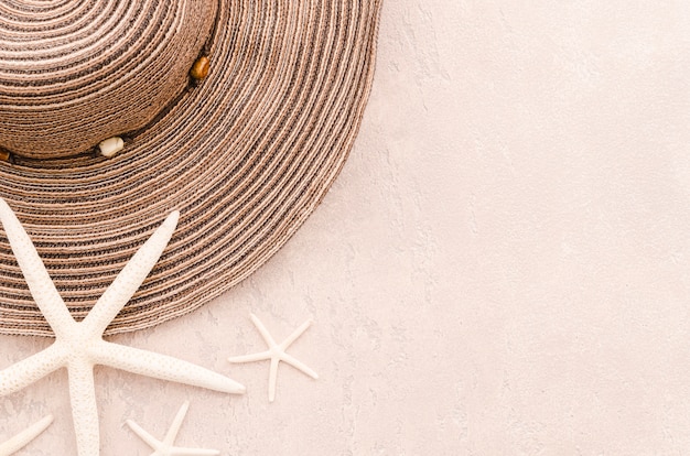 Chapeau d&#39;été femme avec étoiles de mer sur table