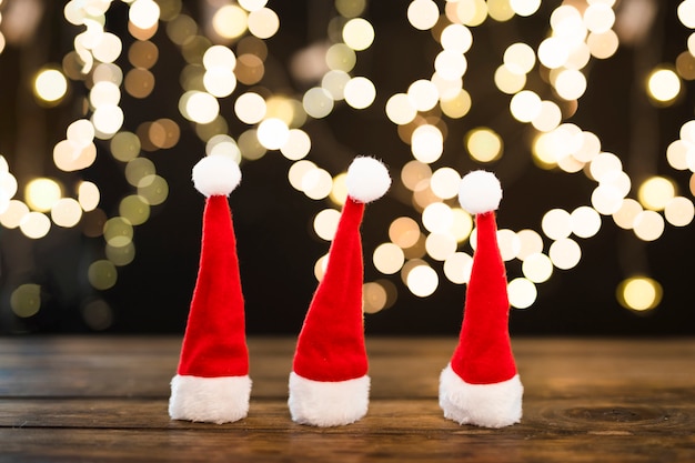 Chapeaux de Noël près de lumières abstraites