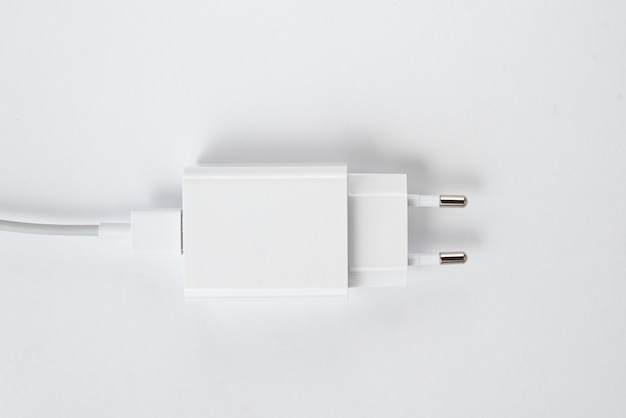 Chargeur de téléphone portable blanc sur fond blanc isolé - avec câble usb