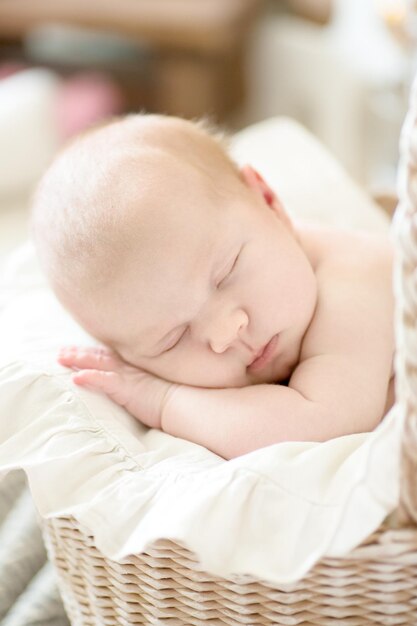 Charmant bébé endormi poussette en osier closeup