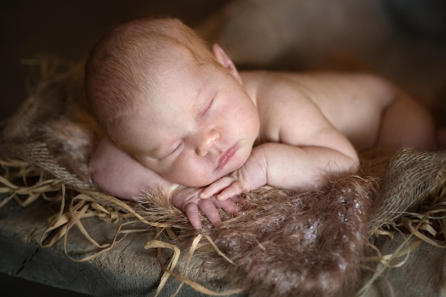 Charmant bébé nouveau-né sur fond marron en bois